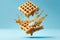 Flying waffles and butter getting dripped with maple syrup over a light blue background. AI generated