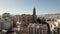 Flyover city rooftops towards Malaga Cathedral, slowly ascending view, Spanish cities