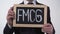 FMCG written on blackboard in businessman hands, consumer goods, retail trade