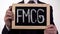 FMCG written on blackboard in businessman hands, consumer goods, retail trade