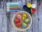 Foam eggs for creativity with paints on a wooden table, painted Easter eggs in the form of a rabbit, a berry, a chicken and the