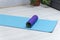 Foam roller for self-massage on blue yoga mat. Equipment for myofascial release. Massage roller. Workout at home