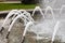 Foamed, dense jets of water burst from metal nozzles in the city fountain