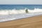 Foaming breaking wave and backwash foam on a sandy shoreline