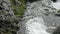 A foaming mountain stream flows quickly through rocky terrain