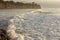 Foaming pastel foam washing across bay with distant wave backwash,