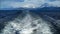 Foaming water at the stern of cruise ship with les eclaireurs lighthouse in the distance, Beagle channel, Ushuaia