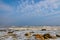 Foamy gray waves beat against coastal stones