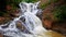 Foamy Stormy Mountain River Flows among Large Rocks