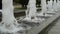 Foamy streams of water rise and fall. Alley of fountains in a city park