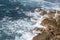 Foamy waves of the surf near the rocky shore