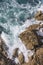 Foamy waves of the surf near the rocky shore