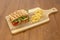 Focaccia sandwich with tomato, sliced buffalo cheese, dehydrated tomato and arugula in quantity with a garnish