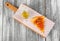 Foccacia with tomatoes and sauce on a cutting board on wooden background