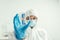 Focus of biochemist in hazmat suit holding petri dish with biomaterial