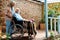 Focus of cheerful senior woman standing near disabled husband in wheelchair