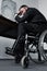 Focus of depressed disabled businessman sitting in wheelchair at workplace