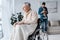 Focus of disabled senior man in wheelchair near son