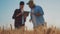 Focus on the ears of wheat. Team farmers stand in a wheat field with tablet and controlling their crops. Agronomists