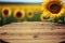 Focus empty wood table with blurred sunflower tree background.