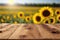 Focus empty wood table with blurred sunflower tree background.