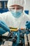 Focus of engineer holding tweezers while testing computer motherboard