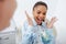 Focus of excited african american woman in braces gesturing near dentist holding teeth model