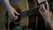 Focus on fingers fingering the strings. Close-up of the hands of a girl playing an acoustic guitar.