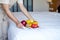 Focus on fruit. A hotel room cleaning maid with fruit put the tray to the bed to welcome the arriving VIP guests