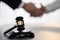Focus gavel on blur background of lawyer colleagues handshake. Equilibrium