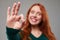 Focus on a gesture of success given by redhead woman