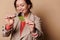 Focus on green leaf in hands of a blurred woman, attentively studying the structure of a plant through magnifying glass