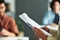 Focus on hands of young female speaker holding document