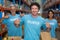 Focus of happy volunteer showing his tee-shirt in front of his team