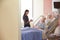 Focus On Hospital Room Sign With Doctor Talking To Patient