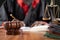 Focus on judge gavel, Unrecognizable judge busy writing verdict or making notes from the book with gavel and balance scale on