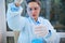Focus on laboratory pipette in the hands of blurred scientist, pharmacologist, clinical researcher pipetting blue liquid