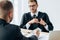 Focus of man giving money to judge sitting and gesturing near table