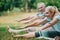 Focus of mature man and woman on yoga mats practicing yoga in park