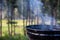 Focus on a portable charcoal grill at a campsite overlooking a green forest