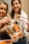 Focus on rolls. Mom and daughter are holding sushi rolls with Chinese chopsticks. Blurred background