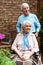 Focus of senior man standing near cheerful disabled wife