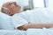 Focus of senior unconscious man lying on bed in hospital