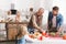 Focus of smiling father and grandparent looking at kid and setting table in Thanksgiving day