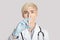 Focus on syringe with medicine in white coat with stethoscope in rubber gloves of middle aged woman doctor