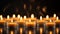 Focus on three lighted candles in front of many others. Generative AI