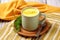 focus on turmeric latte in rustic cup on burlap tablecloth