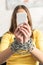 Focus of young woman with tied hands with metal chain holding smartphone