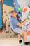 Focused active aged man climbing on bouldering wall