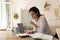 Focused adult female student doing homework, reading books at laptop